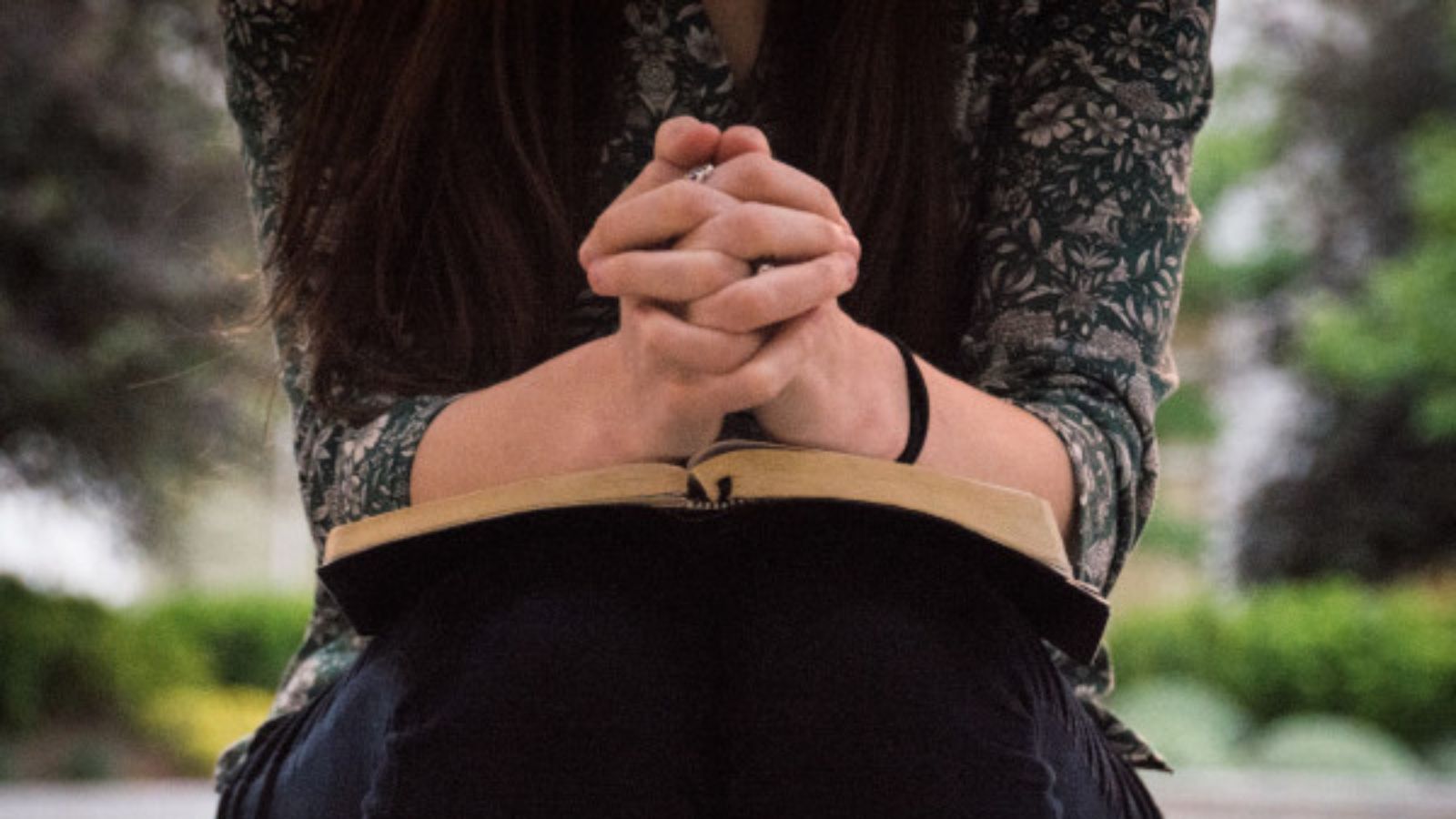 woman praying with a bible in her lap